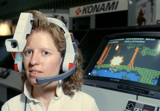 Susan Bach, Marketing Coordinator for Konami, Inc., demonstrates the Laser Scope voice command headset, for use with all Nintendo Zapper games, at the 1990 International Summer Consumer Electronics show in Chicago on Friday, June 5, 1990. The hands-free unit will retail for $39.95. The electronics extravaganza continues through on June 5. (AP Photo/Mark Elias)